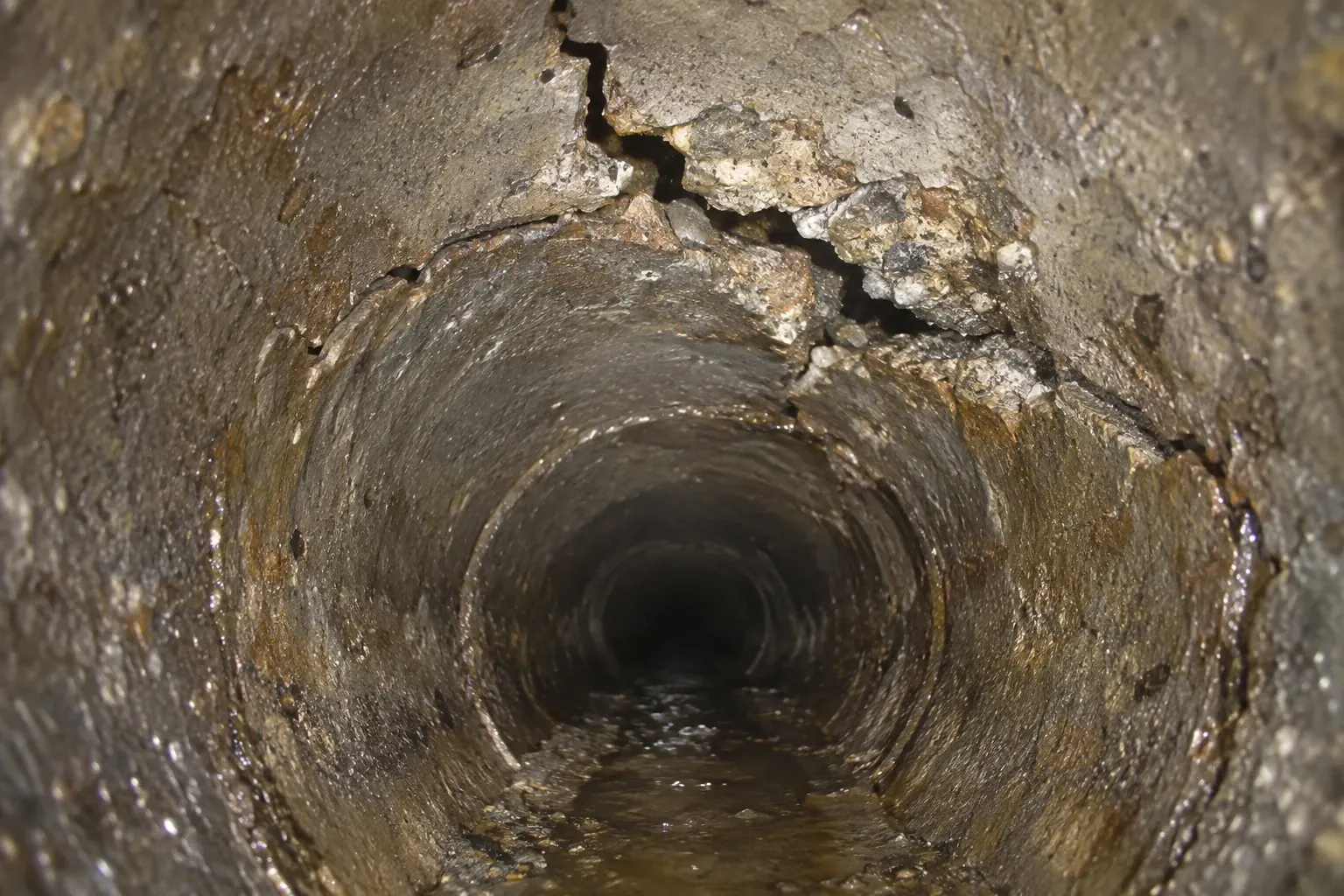 A condition illustration shows a jagged fracture and chipped concrete along the upper wall of a sewer pipe.