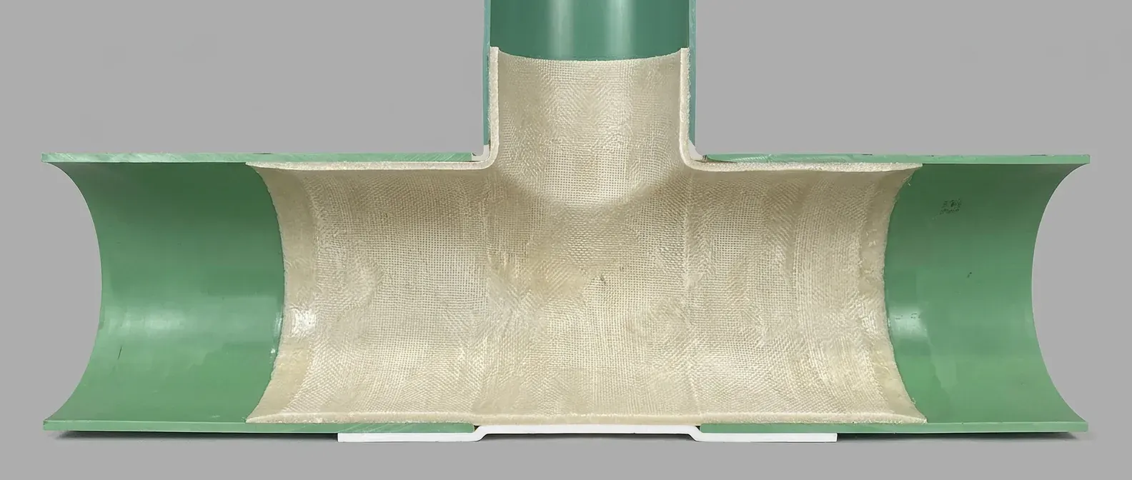 Tee cutaway showing a connection liner spanning the sewer main and extending into the perpendicular lateral.