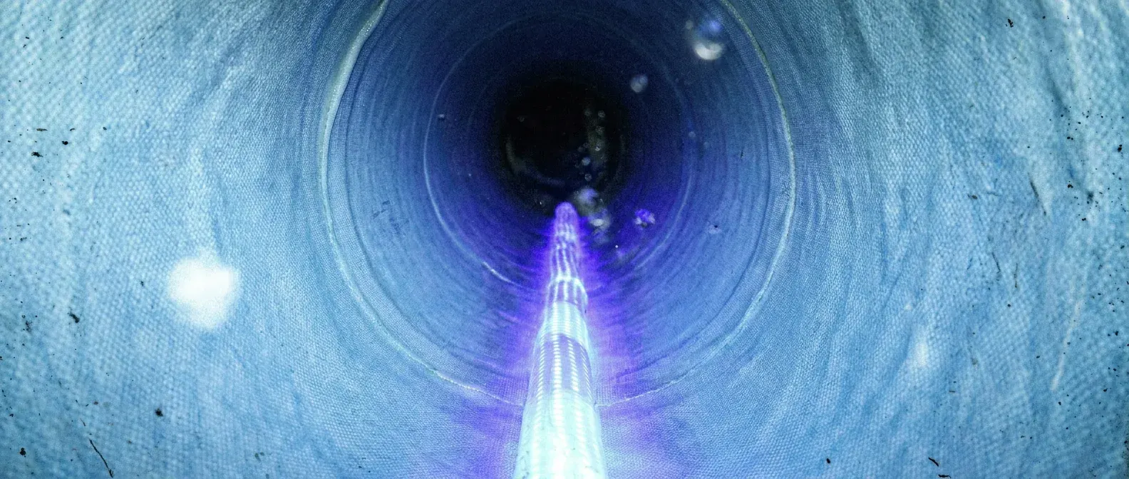 Illustration of an illuminated UV curing train extending through a glass-reinforced liner inside a sewer pipe.